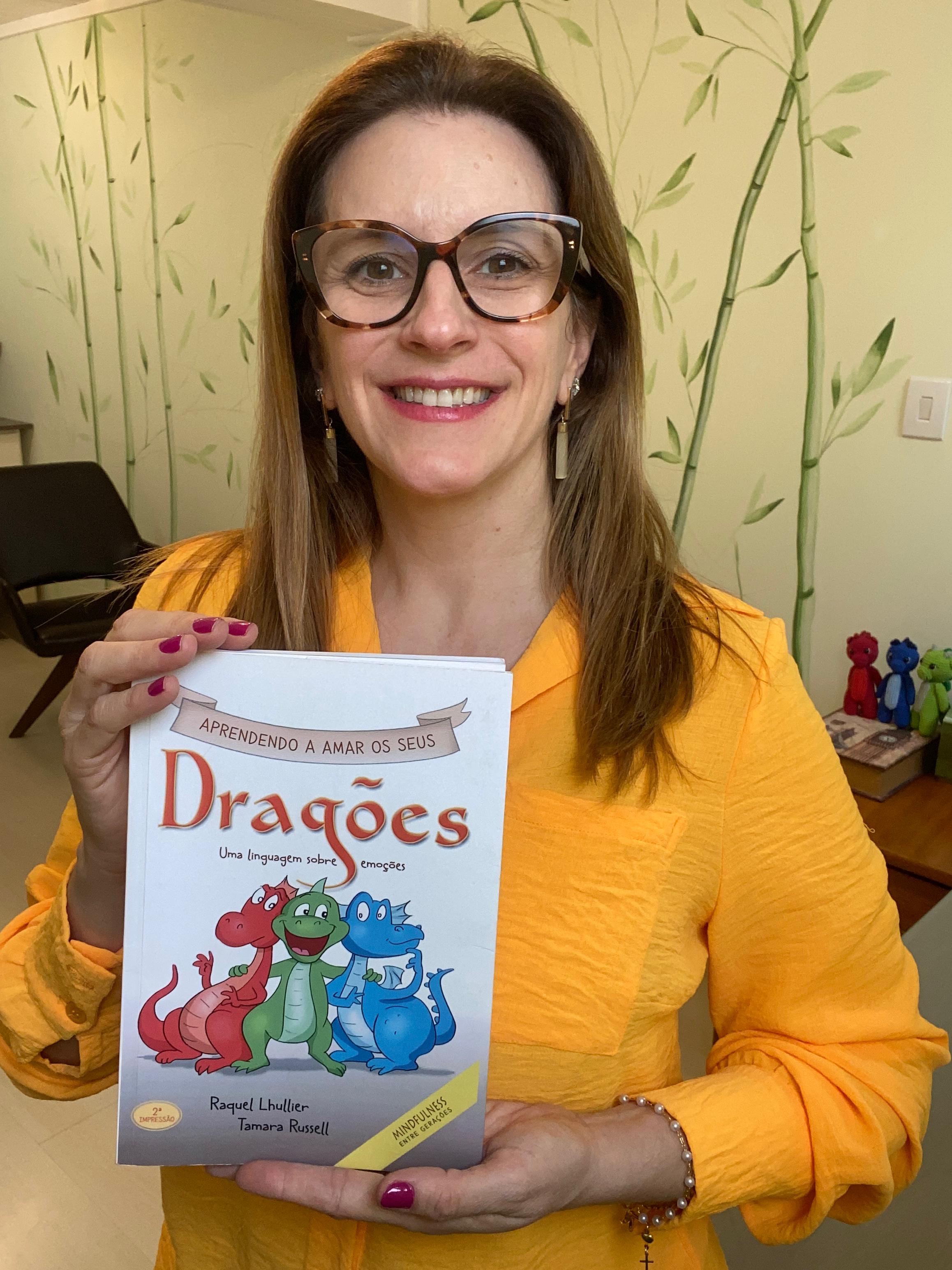 Raquel Lhullier segurando o livro Aprendendo a Amar os Seus Dragões